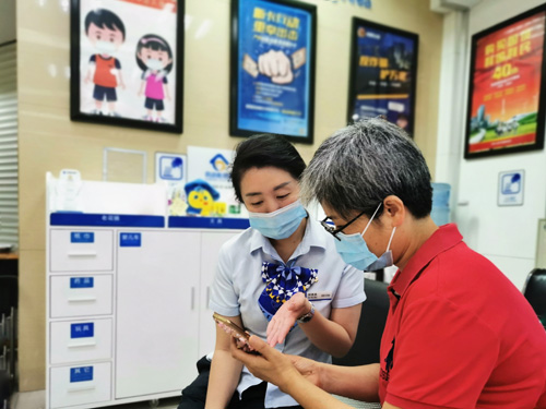 建行成都第六支行，大堂經(jīng)理為客戶介紹手機銀行&ldquo;大字&rdquo;模式